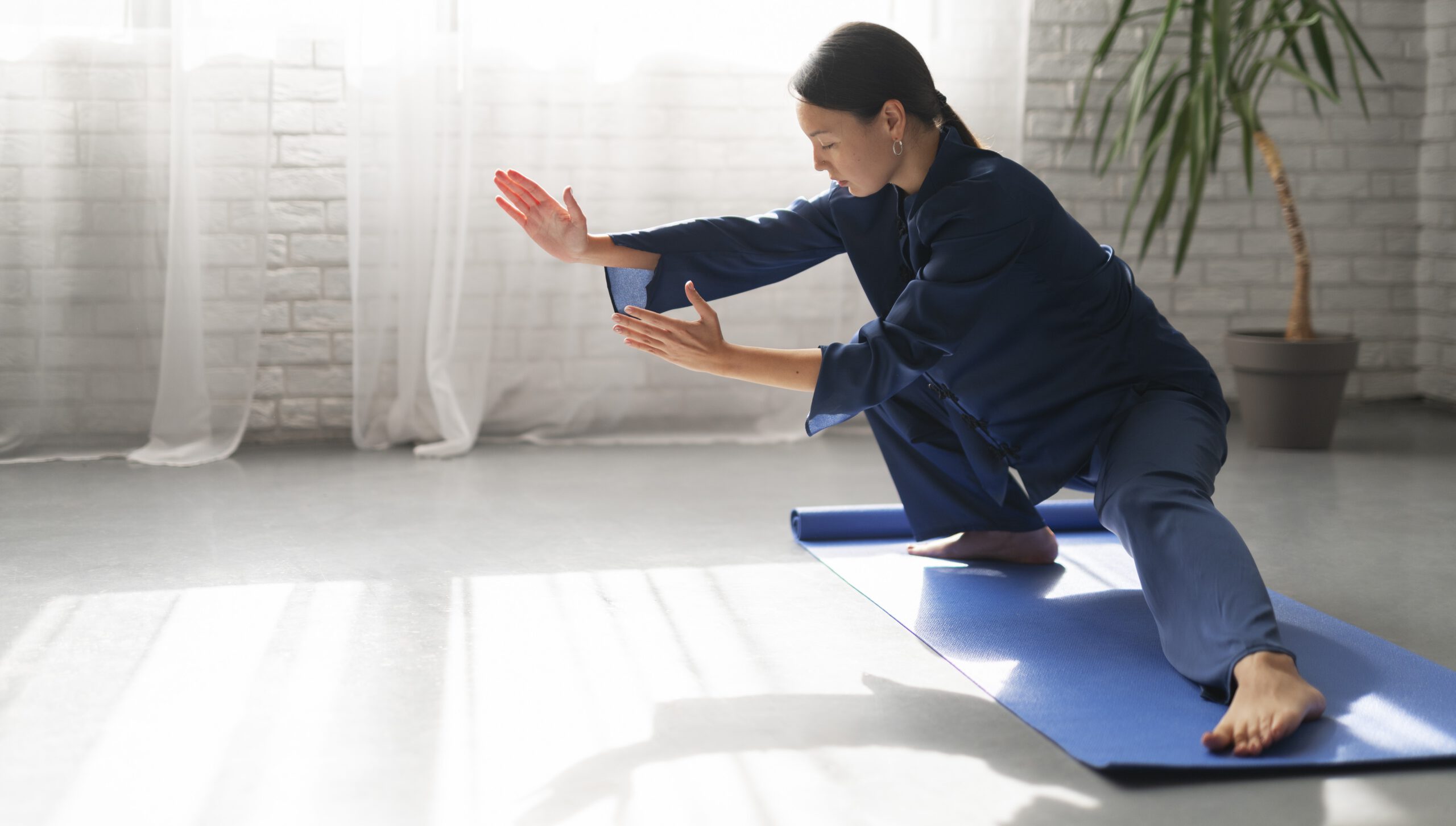 2023 12 11 frau die drinnen tai chi praktiziert